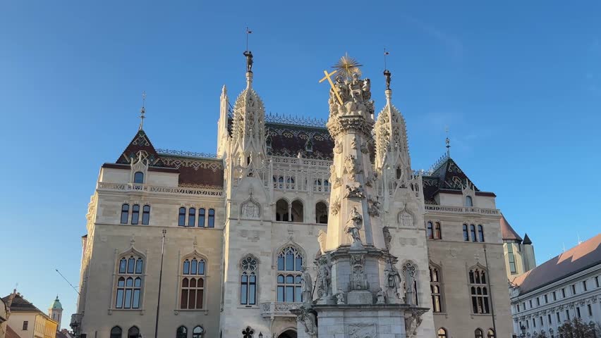 Historical buildings of Royal Ministry of Finance, Holy Trinity Statue and part of facades of Matthias Church on the Holy Trinity Square in Budapest, Hungary, view close-up while panning
