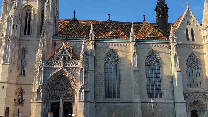 South facade of Gothic Matthias Church of the 14th century in Budapest, bottom view close-up while vertical panning against the clear sky
