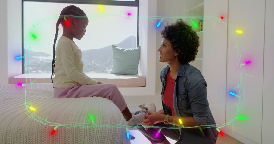 Mother kneeling after girl extending foot, fastening sock getting ready, parenting overlay framing. Bonding, parent, caregiving, child, footwear, shoe, bed