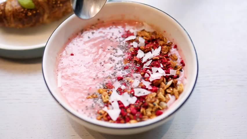 Pink Smoothie Bowl Topped with Granola, Berries, and Coconut Flakes
