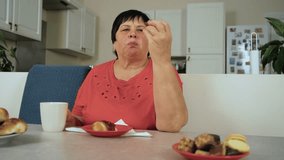 Woman eating chocolate cookie in kitchen. Female having sweet biscuit indoors. Lady consuming dessert snack at home. Mature woman enjoying chocolate treat in cozy kitchen - Powered by Shutterstock - Get 15% off with code: PIKWIZARD15