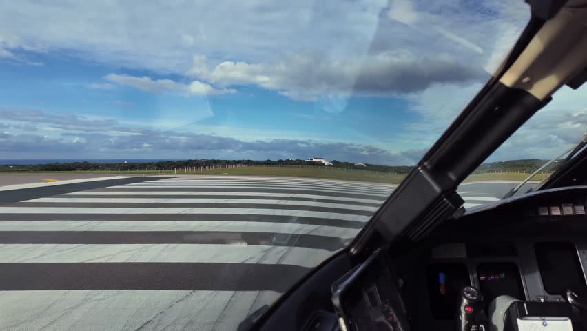 A pilot’s eye view recorded from inside a jet cockpit lining up for takeoff with stormy clouds over the runway