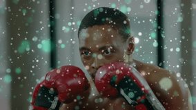 Male boxer fixing gaze, lifting red gloves, throwing punches for boxing, particle drifting over him. Focus, training, athlete, movement, gym, intensity, discipline - Powered by Shutterstock - Get 15% off with code: PIKWIZARD15