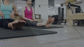 Women on cue in pilates raising arms hinging forward holding feet deepening stretch hand overlays. Yoga, mats, reformer, barre, barefoot, studio, wellness - Powered by Shutterstock - Get 15% off with code: PIKWIZARD15