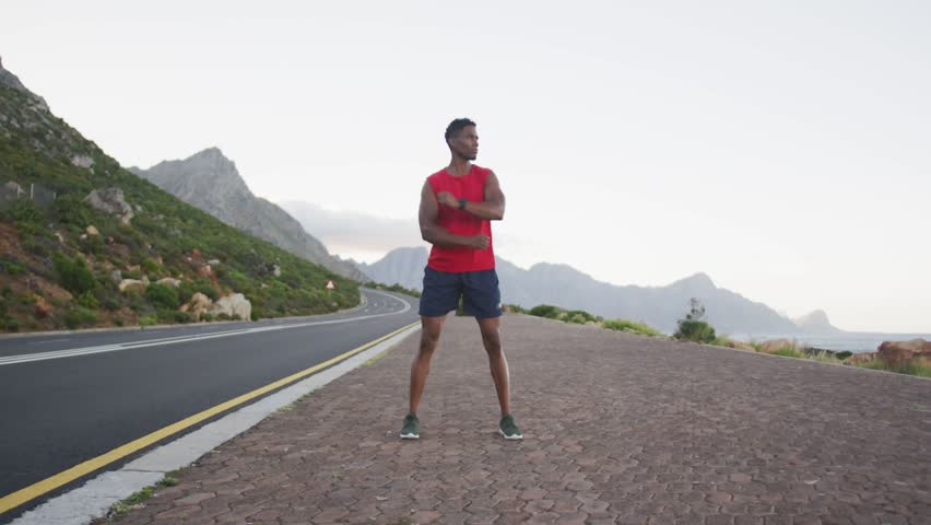 Runner stretching on brick turnout, WOW appearing from right beside runner, warming up for fitness. Athlete, outdoor, mountains, road, warmup, motion, typography