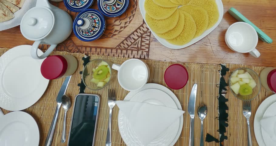 vibrant Moroccan breakfast table displays a variety of traditional foods, including flatbread, pancakes, and decorative dishes