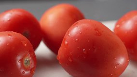 Fresh red tomatoes with water droplets rest on a board. Juicy vegetables shimmering in soft light ideal for salad, health or freshness themes. - Powered by Shutterstock - Get 15% off with code: PIKWIZARD15