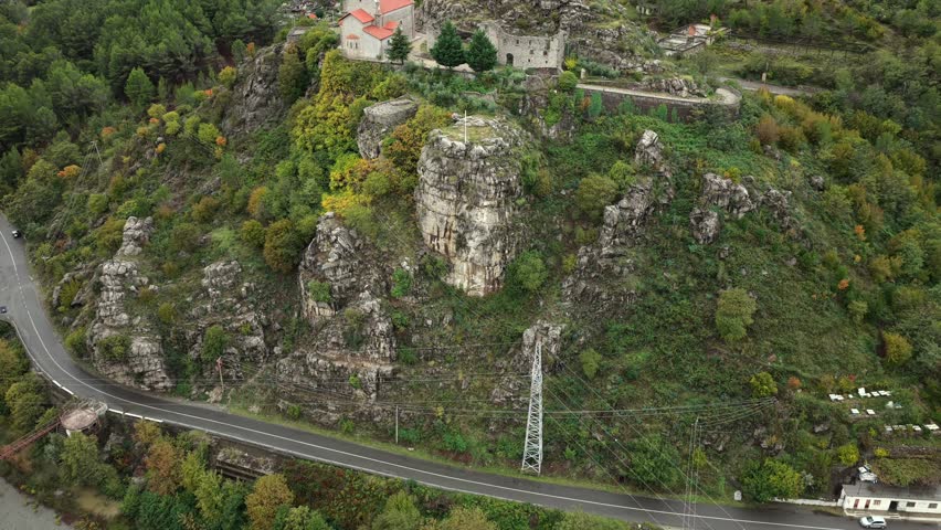 Aerial video of Rubik Monastery set on a rocky hill, surrounded by forests, winding roads and autumn mountains in northern Albania.