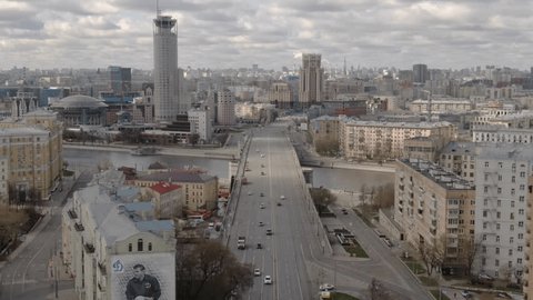Drone Rising Vertically over River Crossing Cityscape