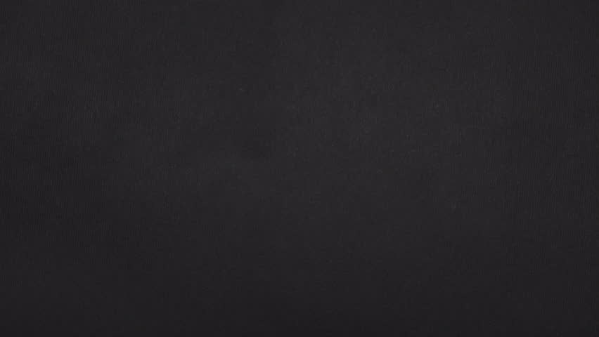 Cross-shaped rips split real black paper into four pieces that pull apart for a bold paper reveal.
