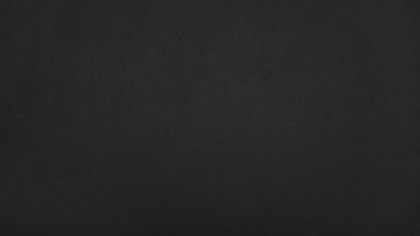 Real black paper tears diagonally to open a vertical gap on the left third, then slides out horizontally.