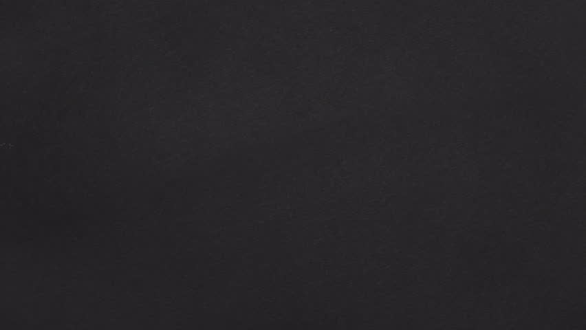 Real black paper is ripped diagonally and pulled straight up, creating a bold vertical paper opener.
