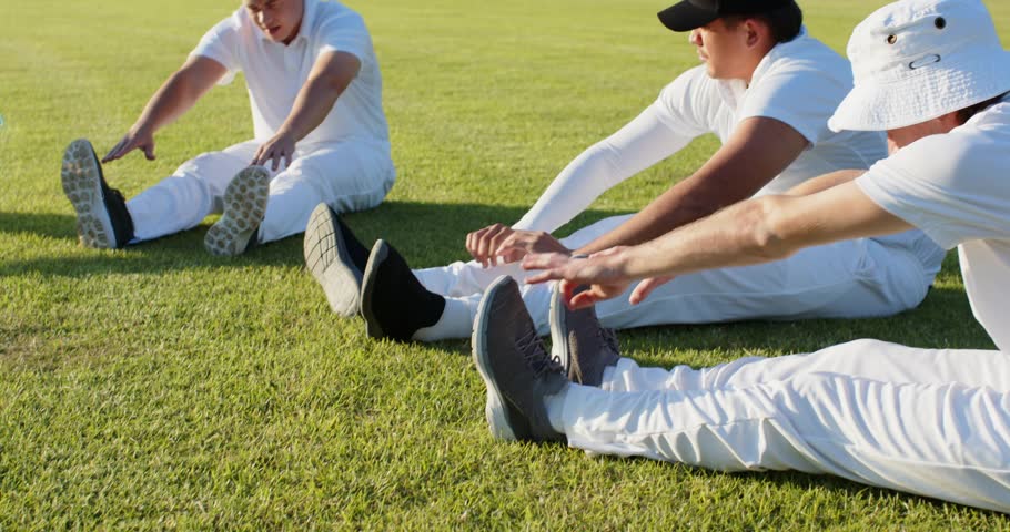 Team stretching, adjusting shoes on sports field, network appearing, highlighting shoes, warming up. Group, outdoor, grass, athletic, footwear, dialogue, overlay