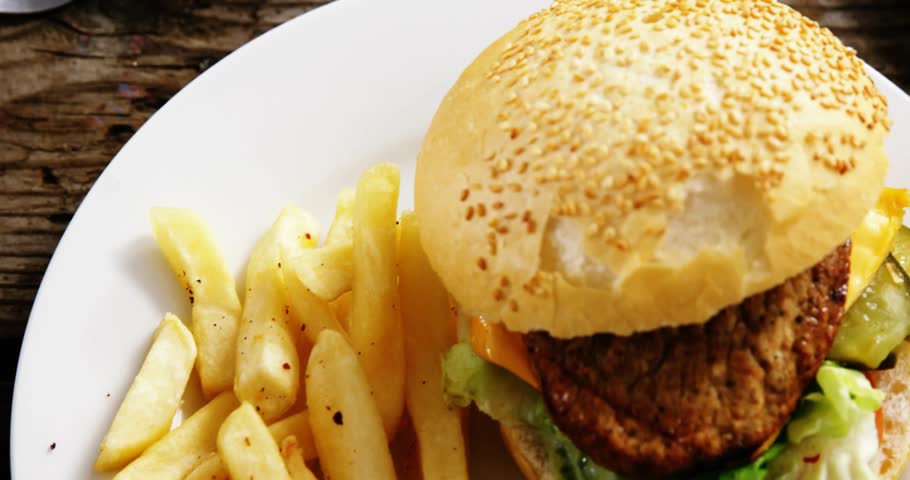 UI icons fading and floating across plates, glitch slicing, burger shifting left, showing menu data. Sandwich, fries, rustic, woodgrain, cafe, duo, animation