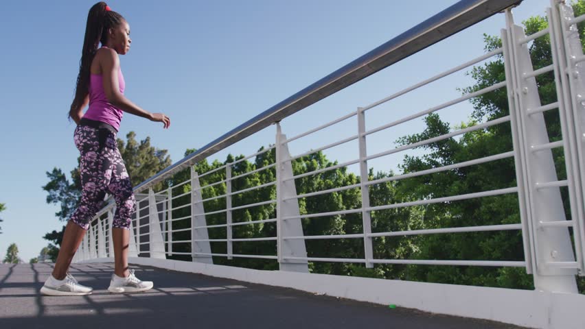 Woman stretching at railing lifting leg warming causing fashion New Collection glitching settling. Athlete, outdoor, fitness, balance, leggings, sneakers, athleticwear