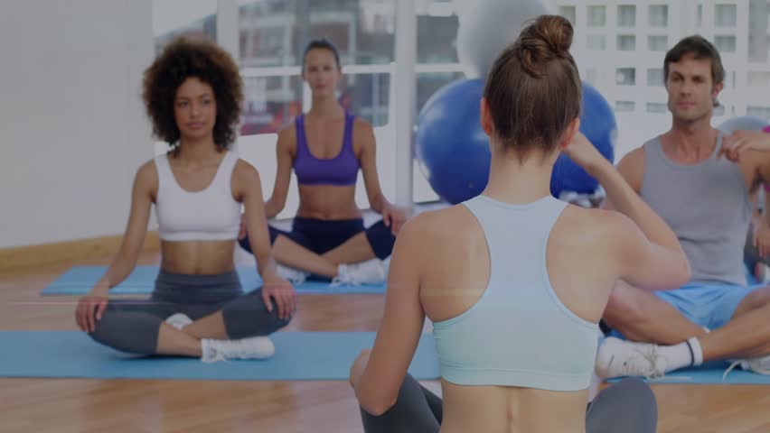 instructor raising arms, leading class mirroring neck stretching for group fitness, NFT HUD rising. Trainer, yoga, mobility, flexibility, studio, daylight, mats