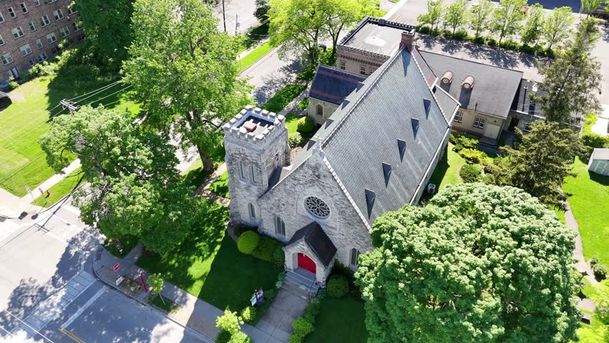 A church designed for those that practice the Episcopalian religion within the heart of a city, covered by lush green foliage.