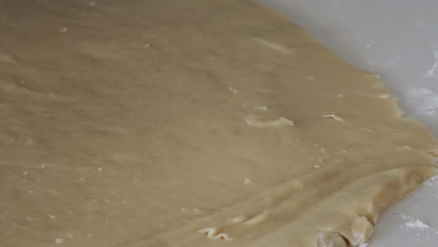 A close up shot of a star shaped cookie cutter being used on cookie dough to cut out star shaped cookies.