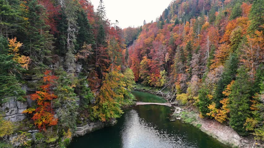 River Doubs as it approach the waterfalll, flows through deep gorge on the border between France and Switzerland within the Jura Mountain,Franche-Comté region, displaying vibrant autumn foliage