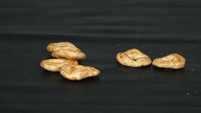 A person places and rearranges ring-shaped spicy crackers on a dark background. Ideal for snack ads, product showcases, and creative food visuals. - Powered by Shutterstock - Get 15% off with code: PIKWIZARD15