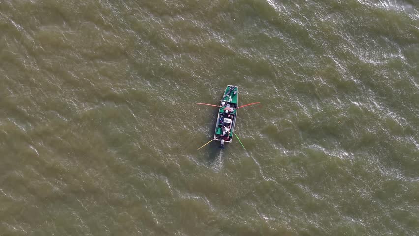 Ascending shot of 2 fishermen in a small boat on the Cumberland River, located in Clarksville, Tennessee