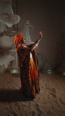 African woman in traditional gown enjoying ethnic music and dancing unique Arabian dance on sand. Old tribe of desert-dwellers, save heritage and ancient culture of ancestors, unique dance show