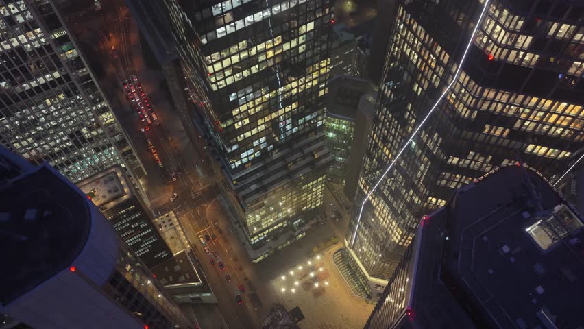High angle aerial view of illuminated skyscrapers in financial district of Frankfurt, Germany. Corporate buildings and streets glow at night