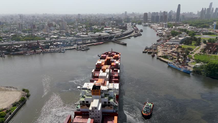 Cargo ship at La Boca Port, Buenos Aires, under sunny skies, urban backdrop