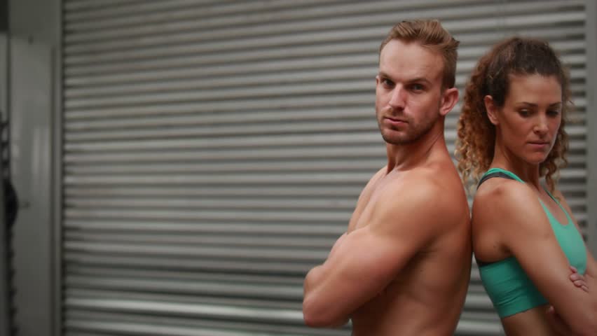 Fitness duo standing back-to-back animated HUD sweeping across frame revealing her face for promo. Workout, urban, industrial, athletic, teamwork, hud, overlay
