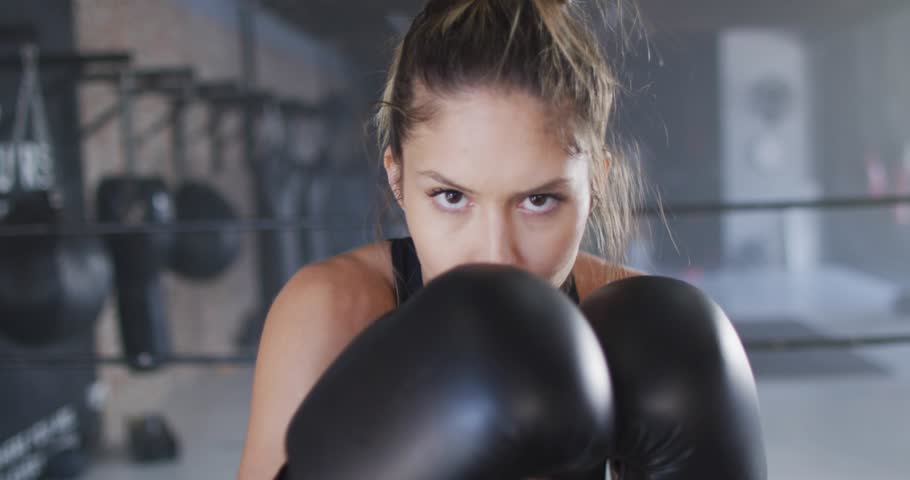 Female boxer shifting weight, throwing jabs for training, HUD tracking force, glove blocking view. Boxing, fitness, dynamic, sports, gym, focus, determination