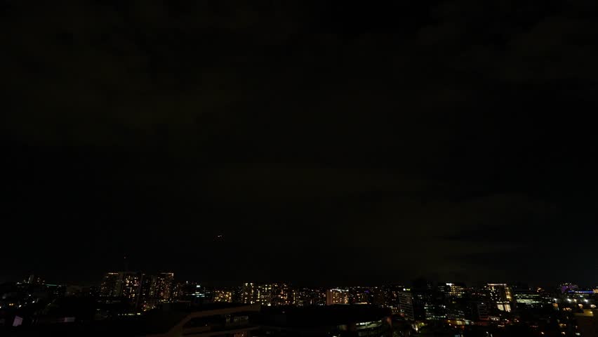 A massive storm cell unleashes its fury over Brisbane, with intense lightning illuminating the dark sky and severe thunderstorms pounding Southeast Queensland.