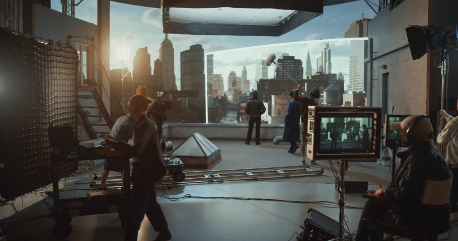 Diverse Male Actors Perform an Intense Rooftop Scene on a Studio Stage, Film Crew Directs, Operates Camera and Monitors, Coordinates Graphics on Virtual Production City Screen