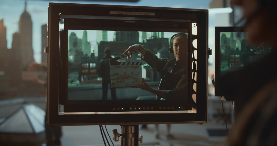 Film Crew Tracks a Rooftop Standoff on a Dolly, Monitoring Actors Through On-set Screens While Led Wall Renders Virtual City Scenery, Blending Practical Set, Cinematic Virtual Production.