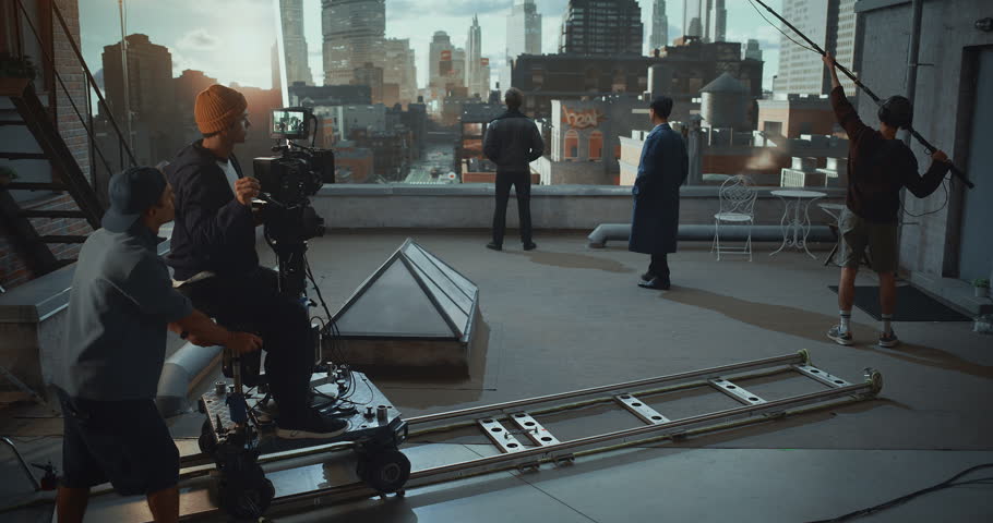 Camera Operator Rides a Dolly on Rooftop Movie Set, Actors Perform Great Dramatric Dialogue While Monitoring Framing on Monitor and Using Virtual Production, Cinematic Movement and Visual Aesthetics.