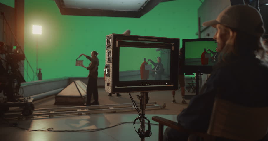 Professional Film Crew Shoots Caped Superhero Movie on Chroma Key Green Screen Stage Set. Filming of Dramatic, Cinematic Visuals and Aesthetically Innovative Blockbuster Scenes