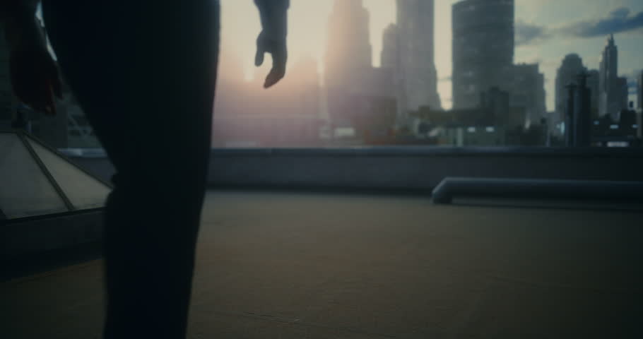 Superhero in a Bright Red Cape Walks Across a Rooftop, Steps Heroically Edge, Surveying the Futuristic City Below in Dramatic Light. Cinematic Trailer, Streaming Promo, or Powerful Brand Commercial.