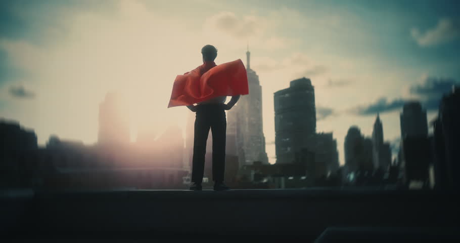 Male Superhero Stands on Rooftop, Cape Rippling as He Holds a Strong Pose Facing the City Crime. Mock‑up Footage Ideal for Screen Replacement, Virtual Fiction Segments, Title Sequences, Trailers