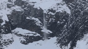 Snow cascades down a steep Antarctic cliff, revealing dark rock and frozen slopes in a harsh polar environment. - Powered by Shutterstock - Get 15% off with code: PIKWIZARD15
