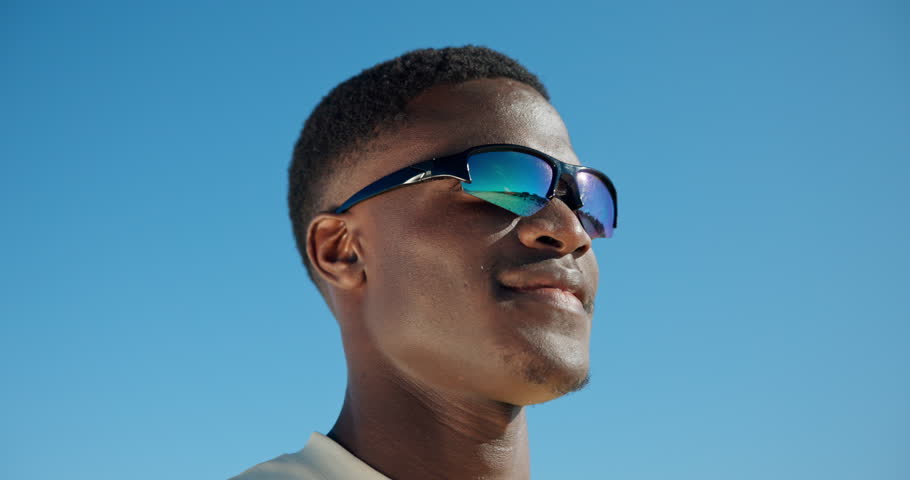 Happy, man and sunglasses for summer vacation, blue sky or think with smile on trip and mockup space. Outdoor, low angle and black person with shades for holiday, reflection and excited for break