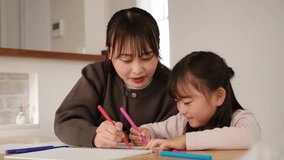 Cheerful Asian mother and her little daughter enjoying creative time drawing with markers at home - Powered by Shutterstock - Get 15% off with code: PIKWIZARD15
