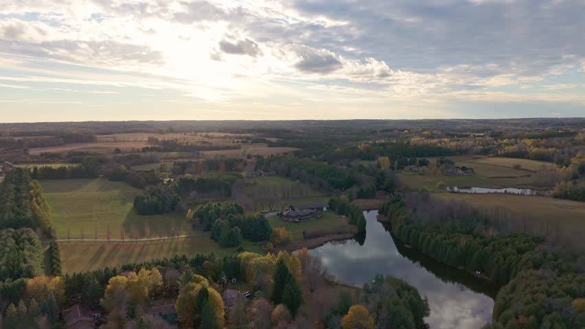Sunset aerial of Millcroft Inn and Spa in Alton, Caledon, Ontario, showing the mill pond, forest edge and rolling countryside during the transition from late fall to early winter.