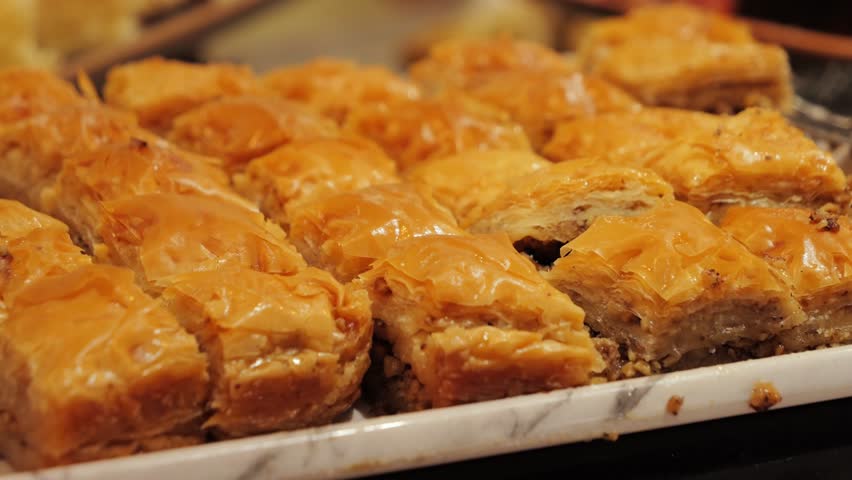 Traditional Turkish Baklava. Close-up of sweet pastry with golden flaky layers, nuts and glaze. High quality 4k footage