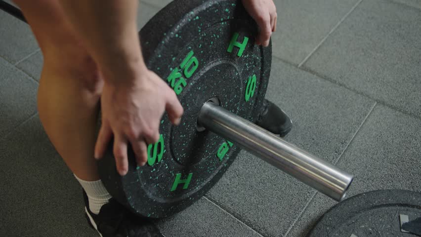 Woman lifts weights in gym during workout session focusing on strength training and physical fitness