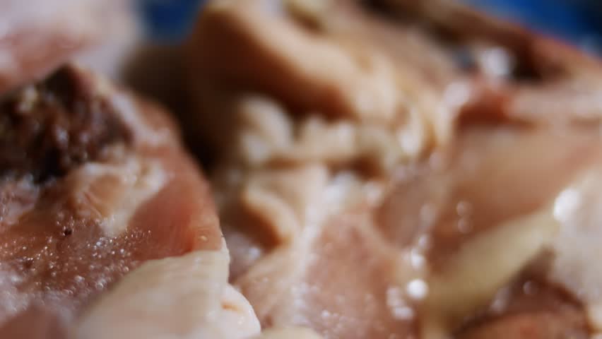 Macro view of frozen raw chicken meat covered with ice