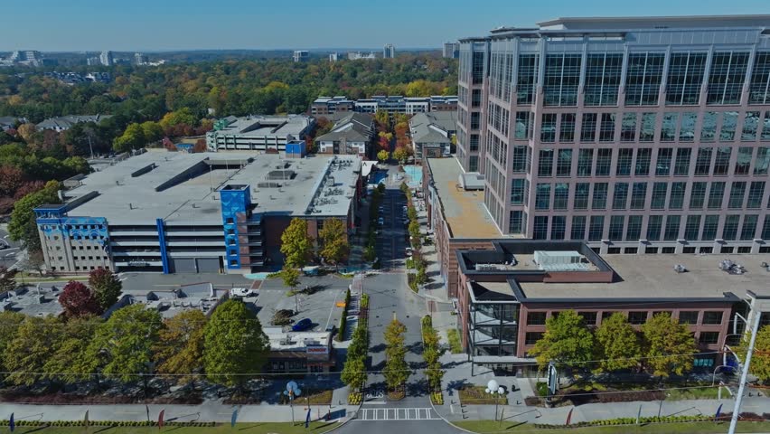Buckhead, Atlanta, Georgia, United States of America - A Wide City View Featuring Tall Office Buildings, a Large Parking Structure, and Tree-lined Streets - Aerial Drone Shot