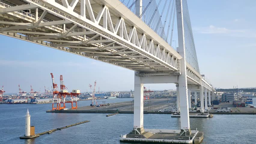 A wide shot of the Yokohama Bay Bridge taken from the cruise ship top deck, capturing ocean views and towering bridge spans