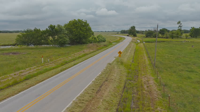 Paved Road Through Open Rural Fields Near Cherokee City, Arkansas, USA. Aerial Drone Shot