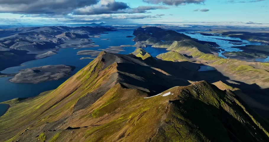 A massive IMAX-style dolly-right sweep over Iceland’s razorback ridge, unveiling deep blue lakes, fractured valleys and towering highlands in an ultra-epic, hyper-cinematic reveal.