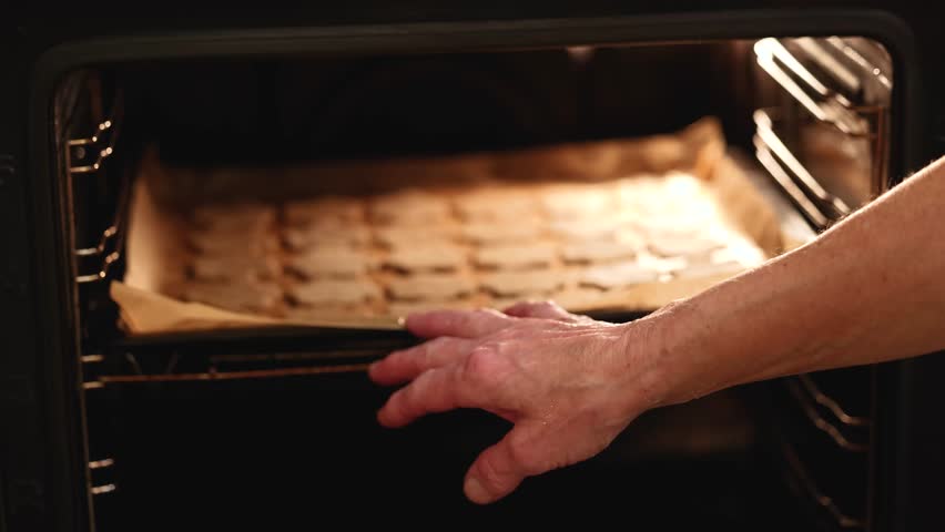  Fresh cookie dough shapes on baking tray inside oven showing authentic Christmas preparation