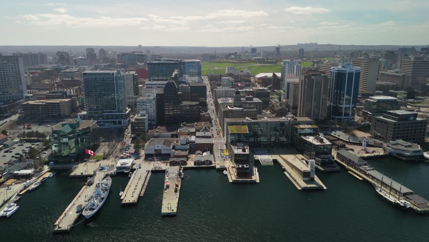 Aerial View Highlights Halifax Nova Scotia Canada With Tall Glass Towers Marina Yachts And Tourists Walking Beside The Waterfront Under Warm Summer Sun Creating A Lively Urban Scene